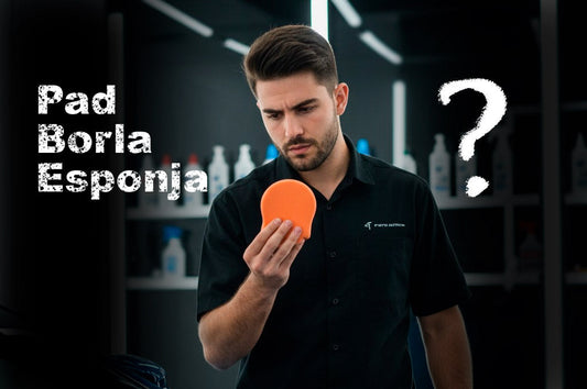 Un detallador profesional, vestido con camisa oscura, mira con gesto de confusión un pad de pulido naranja brillante que sostiene en su mano. Sobre su cabeza hay un signo de interrogación blanco y las palabras "Pad Borla Esponja" escritas en grande